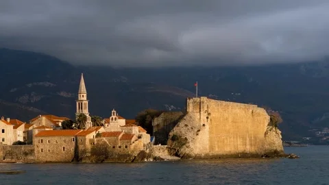 Calm waves and old town of Budva, Montenegro at sunset Stock Footage 346539638