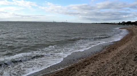 Calm waves breaking on Lee-on-the-Solent beach. Fawley on the horizon Stock Footage 45593991