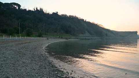 Calm waves gently hitting coastline at sunset Stock Footage 150887495