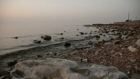 Calm waves gently hitting coastline at sunset Video stock 150888299