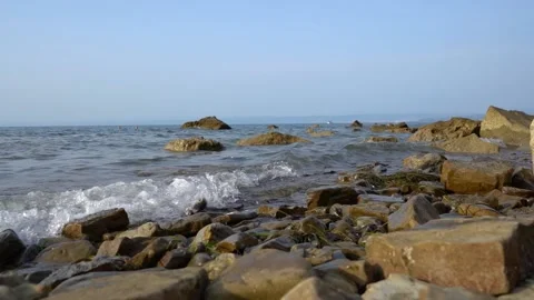 Calm waves hitting rocky shore. Bright sunny day Stock Footage 159062872