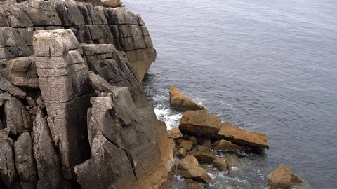 Calm waves of the ocean beat against the rocks Видео 116680177