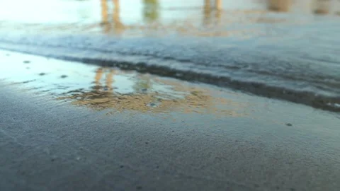 Calm waves of the river roll onto the shore against the background of the bridge Video stock 148104063