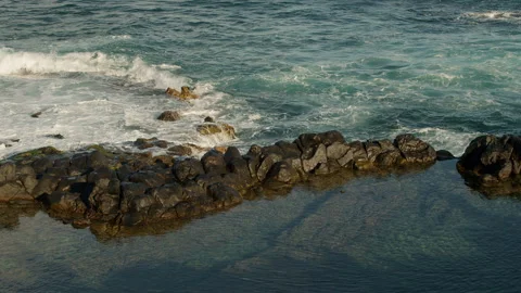 Calm waves rolling over the lava field Stock Footage 247074906