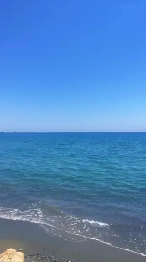Calm Waves on Sandy Beach in Cyprus Under Blue Sky 4K Vertical Video 스톡 동영상 335932601
