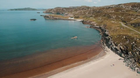 Calm waves on a scenic beach overlooking a white house in Scotland 動画素材 113740826
