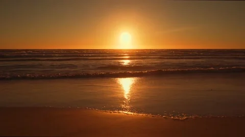 Calm waves splashing on sandy beach at sunset Stock Footage 148633863