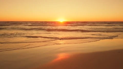 Calm waves at sunset on sandy beach Stock Footage 148633945