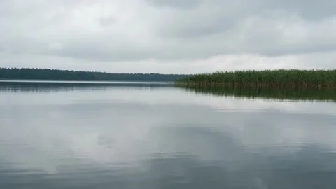 Calm, wide lake with clouds reflection in water Stock Footage 157058228
