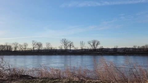 Calm Winter River with Bare Trees Blue Sky and Gentle Water Movement Stock Footage 331266097