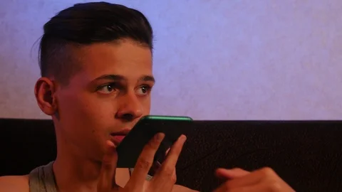 Calm young guy talking on the phone in the room Video stock 106370962