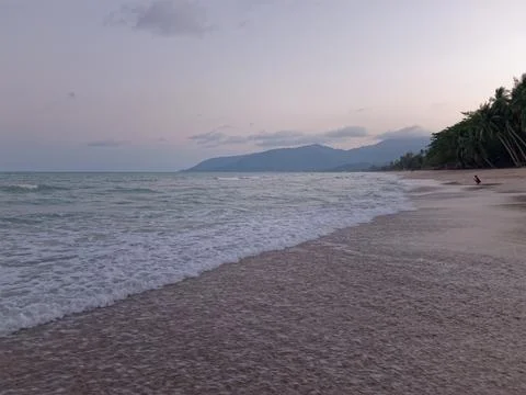 Calmful ocean beach dusk with deep blue sky and breezing waves. Stock Photos