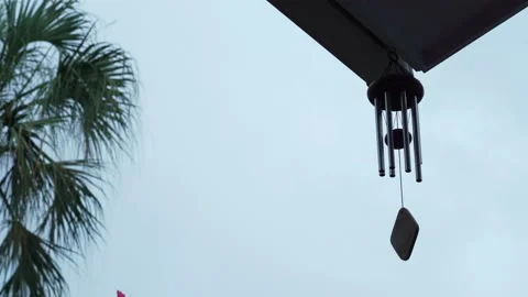 Calming and relaxing view of a wind chime blowing in a tropical garden Stock Footage 162203533