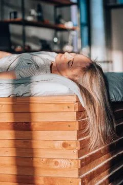 Calming effect of the sunlight bathing the room and the woman as she rests 库存照片