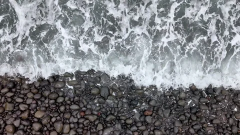 Calming top view of ocean water and smooth round stones on pebble beach.Seashore Stock Footage 313266558