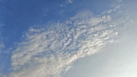 A calming view of the sky filled with delicate cloud formations that seem to Stock Photos