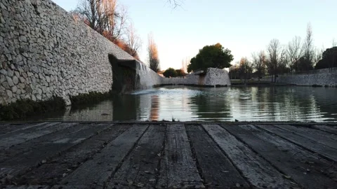 Calming view of small lake and waterfall in a park during the sunset Stock Footage 146956393