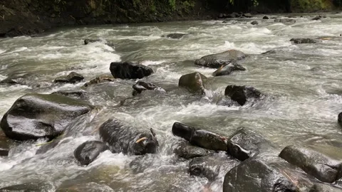 Calming water flow between rocks at Ciujung River, West Java, Indonesia Stock Footage 312395479