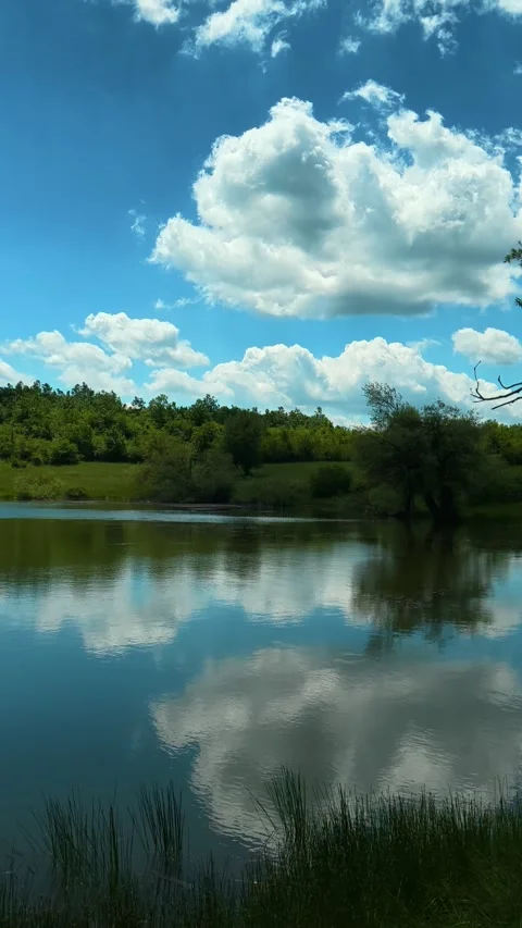 Calming waters mirror a vibrant sky. Vrmdza Lake, Serbia. Vertical Vídeos de archivo 338029683