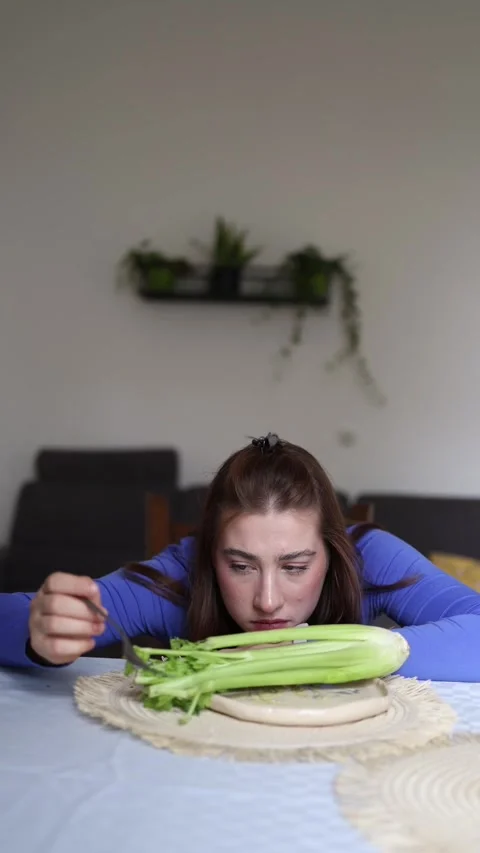 Calorie obsession limits her to celery Stock Footage 339854839