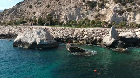 Calpe mountain view during summer kids playing in the rocks jumping Stock Footage 130645191