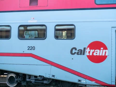 Caltrain logo on side of train next to passenger windows Stock Photos