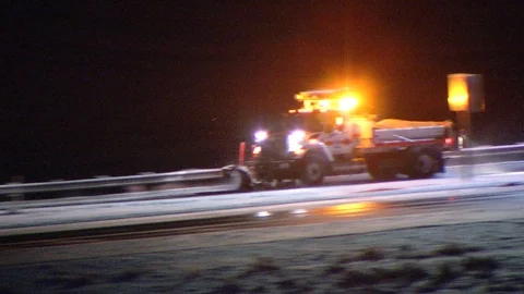 CalTrans snow plows clear snow from the freeway at night Stock Footage 110448465