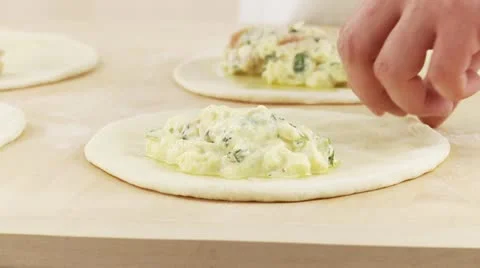 Calzone being prepared: dough being folded over the filling Stock Footage 24650643