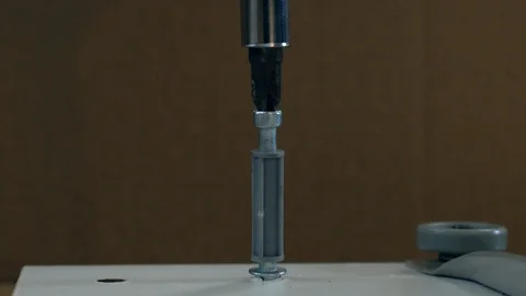 A Cam Lock Screw is inserted using an electric drill Stock Footage 98661697