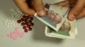 Cambodian Riel KHR, Counting Drugs and Money, Health Care, Colorful Pills HD Footage