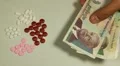 Cambodian Riel KHR, Counting Drugs and Money, Health Care, Colorful Pills HD Footage