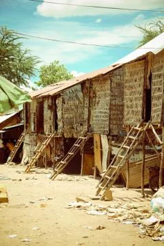 CAMBODIAN SLUM, BASIC HUTS ON DUSTY DIRT ROAD Stock Photos