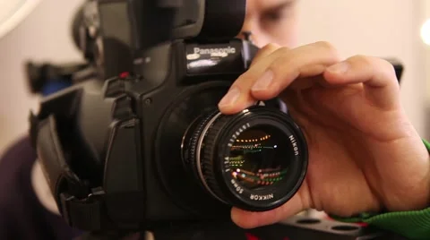 Camcorder operator adjusts the focus of the lens Stock Footage 43306295