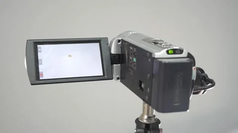 The camcorder on the tripod is in recording mode Stock Footage 163716940