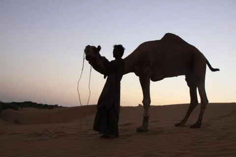 A camel guide poses for photos with his camel in the Thar Desert of Rajasthan Stock Photos