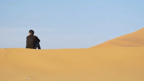 Camel shepherd sitting in Erg Chebbi desert Stockbeeldmateriaal 111277795