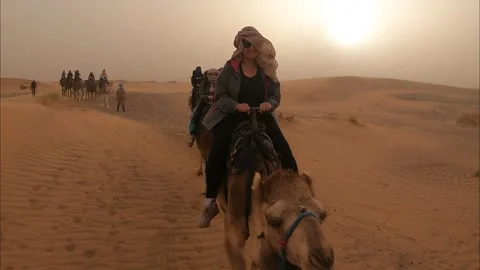 Camel walking through desert in tourists group. Vídeos de archivo 270765667