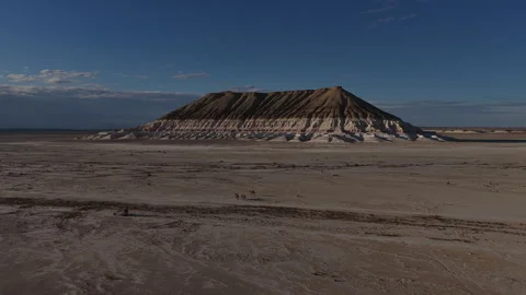 Camels walking through a vast Bokty mountain with a butte Stock Footage 322187675
