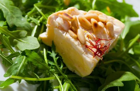 Camembert on arugula with pine nuts Stock Photos