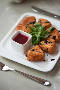 Camembert in batter, deep fried,with balsamic vinegar and arugula Stock Photos