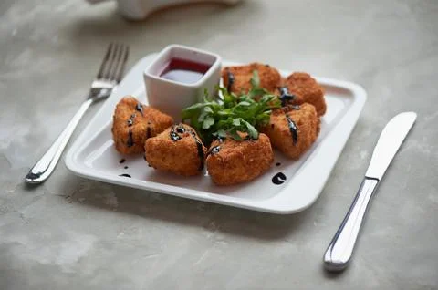 Camembert in batter, deep fried,with balsamic vinegar and arugula Stock Photos