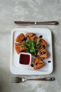 Camembert in batter, deep fried,with balsamic vinegar and arugula Stock Photos