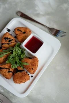 Camembert in batter, deep fried,with balsamic vinegar and arugula Stock Photos