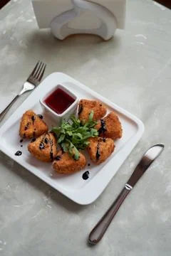 Camembert in batter, deep fried,with balsamic vinegar and arugula Stock Photos