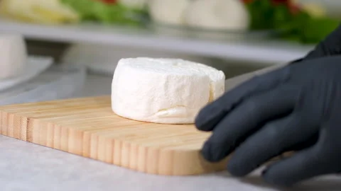 Camembert, Cooking process, Step by step worker at a craft cheese factory turns Stock Footage 302821835
