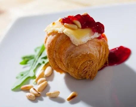 Camembert on mini croissant with jam, pine nuts Stock Photos