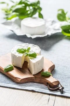 Camembert or brie cheese with basil leaves on table 写真素材