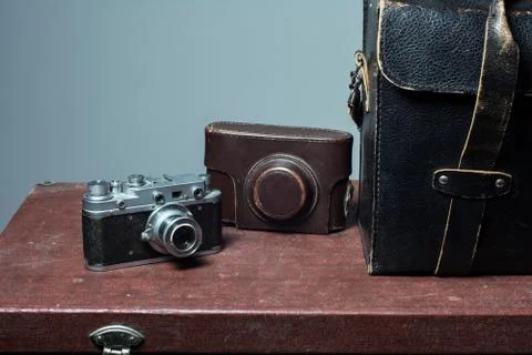 Camera and carrying case on old suitcase Stock Photos