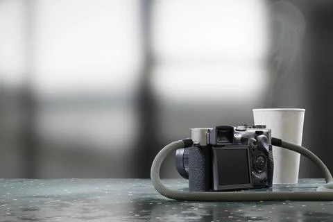 Camera and coffee cup placed on table with blurred background 3d rendering 스톡 일러스트