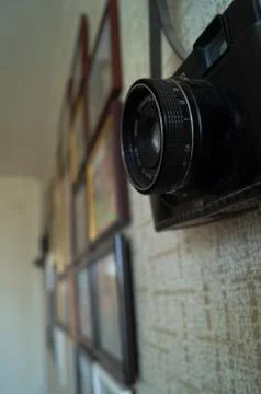 Camera and frames on the wall. Camera lens on the wall. Stock Photos